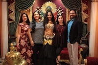 a group of people posing for a picture in front of an ornate room