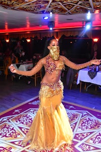 a woman in a gold dress performing a belly dance